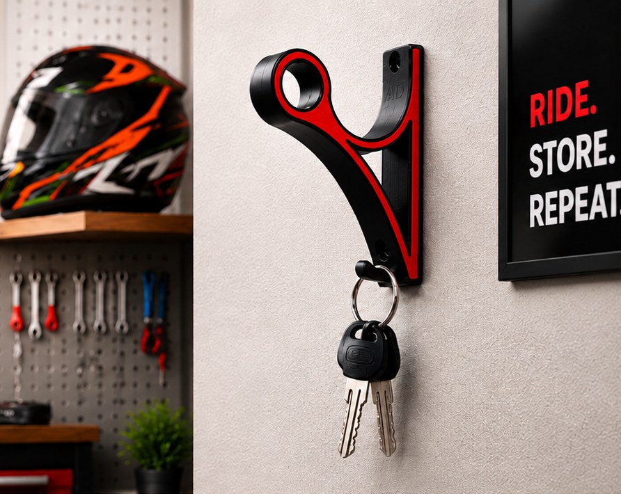 The mount screwed to a workshop wall with keys hanging from its lower hook, a helmet on the shelf behind and a pegboard of tools.