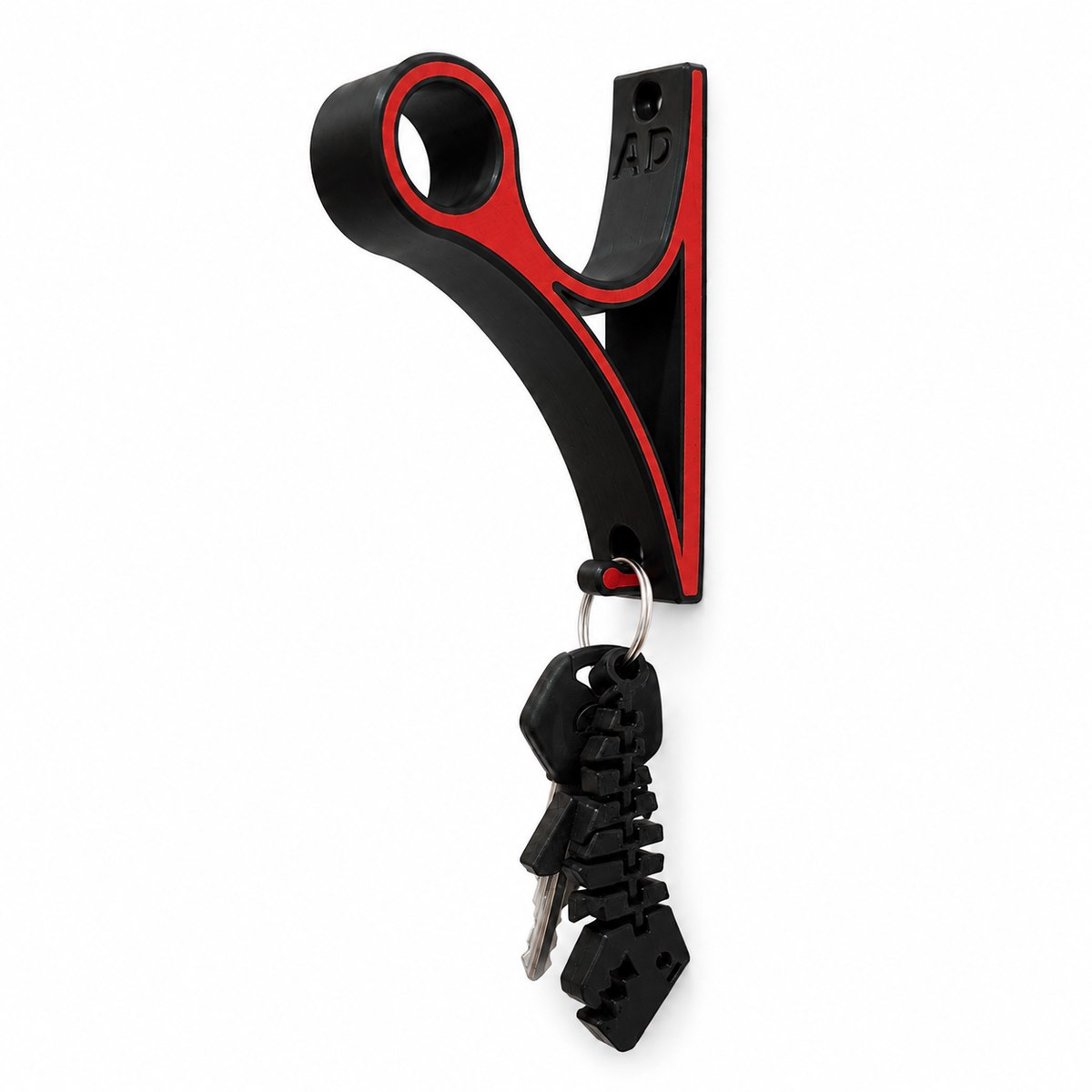 The mount photographed on white — a black body with a red inlay, the round cradle at the top, the AD emboss on the back plate and keys hanging from the lower hook.