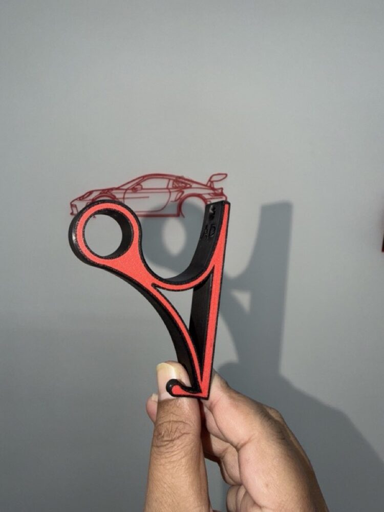 Orange and black mount in hand, casting a shadow on the wall.